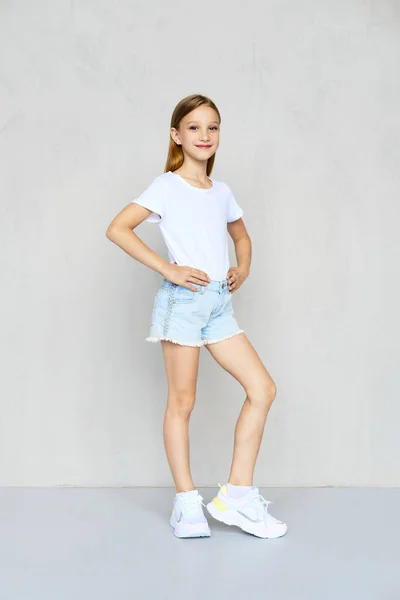Młoda Sportowa Dziewczyna Białym Shircie Jeansowych Spodenkach Rękami Talii Pozowanie — Zdjęcie stockowe