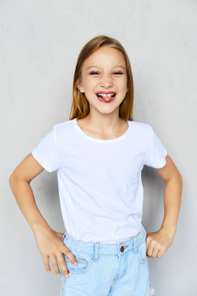 Young sportive girl in white t-shirt sticks out tongue