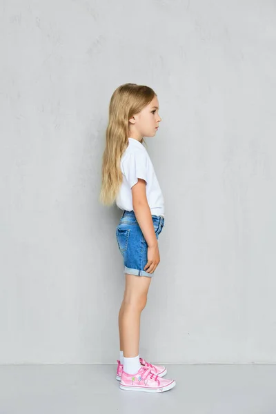 Kleines Mädchen Weißem Shirt Jeans Shorts Und Pinkfarbenen Turnschuhen Profil — Stockfoto