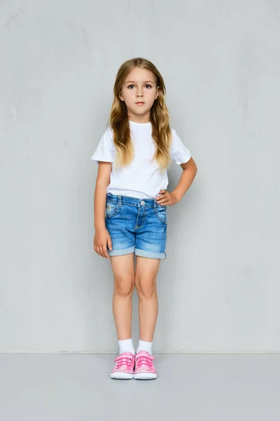 Kleines Mädchen Weißem Shirt Jeans Shorts Und Rosa Turnschuhen Die — Stockfoto