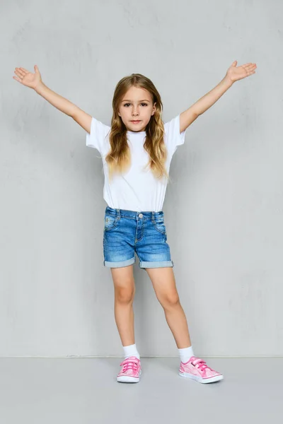Dívka Bílém Tričku Džínách Růžových Teniskách Stojící Zdviženýma Rukama Zdi — Stock fotografie