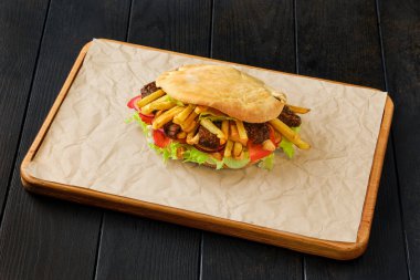 Salata, domates, soğan, patates kızartması ve kuzu etiyle doldurulmuş Pitta ekmeği.