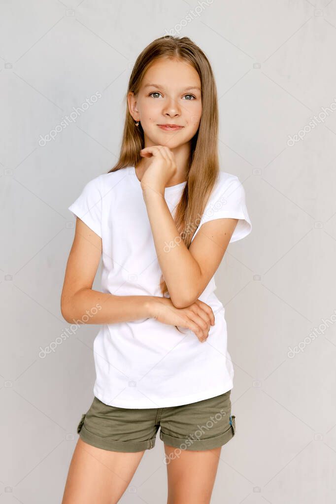 Portrait of positive teenager girl with hand near chin