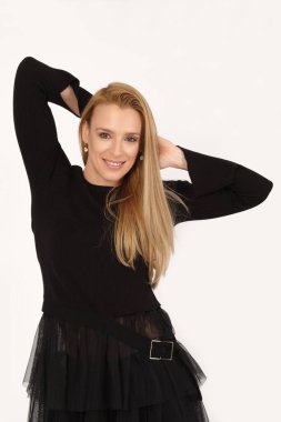 Sarışın kadın, elleri başının arkasında açık gri arka planda