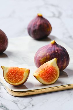 Taze incirler, bütün ve mermer tabakta dilimler halinde kesilmiş.