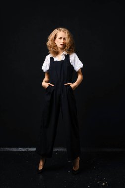 Siyah takım elbiseli, beyaz gömlekli, siyah arka planda güzel bir manken.