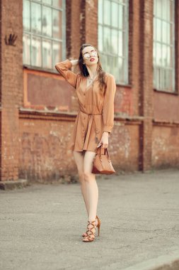 Kulaklıklı güzel bir kadın kaldırımda yürüyor.