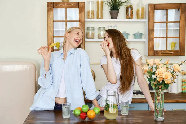 Duas Belas Jovens Mulheres Comem Frutas Cozinha — Fotografia de Stock