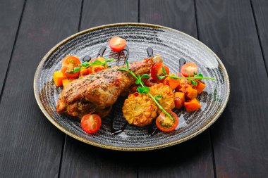 Kızarmış hindi budu, kızarmış kabak ve domatesle süslenmiş ızgara mısır.