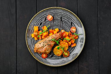 Kızarmış hindi budu, kızarmış kabak ve domatesle süslenmiş ızgara mısır.