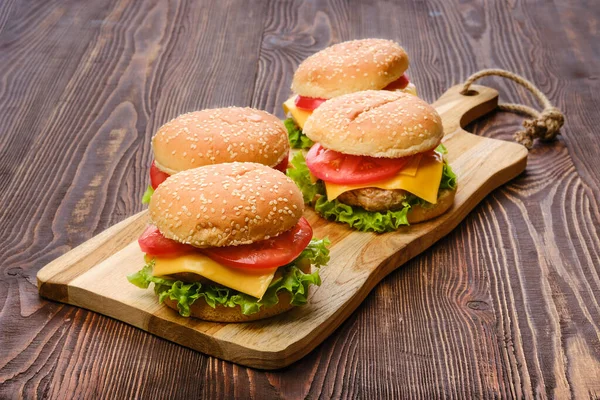 Tahta servis panosunda dört ev yapımı hamburger.