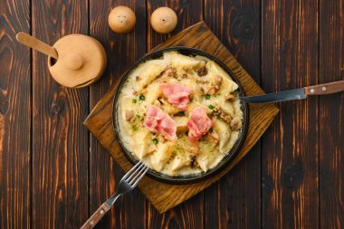 Tavanın üst görüntüsü, kızarmış et, domuz pastırması ve mantar soslu börek.