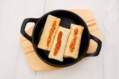 Dökme demir tavada hindi etiyle doldurulmuş ince krep manzarası.