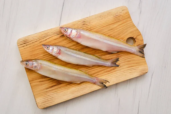 Tahta kesme tahtasındaki taze taze taze balık manzarası.