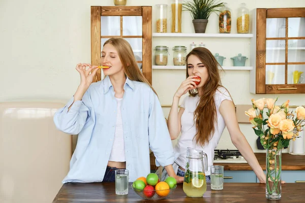 Duas Belas Jovens Mulheres Comem Frutas Cozinha — Fotografia de Stock