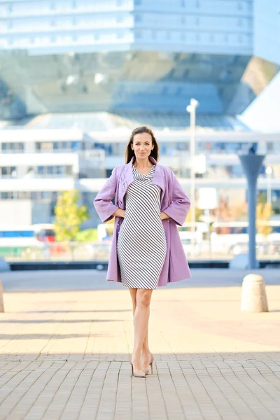 Модна Жінка Бузковому Пальто Смугастій Сукні Позує Відкритому Повітрі — стокове фото