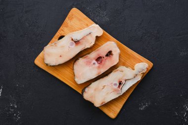 Top view of fresh raw cod steak on wooden cutting board with spice clipart