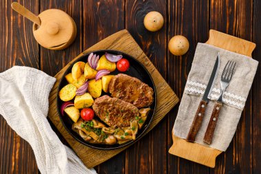 Patates dilimli sığır filetosu taze soğan, domates ve ballı mantar sosuyla servis ediliyor.