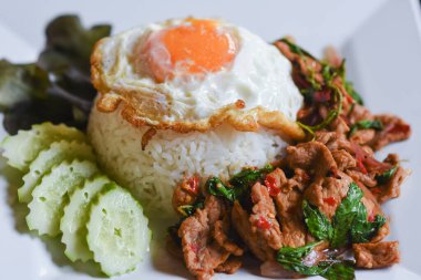 Fesleğenli domuz eti ve pirinçli kızarmış yumurta masada yemek için hazır..