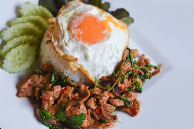 Fesleğenli domuz eti ve pirinçli kızarmış yumurta masada yemek için hazır..