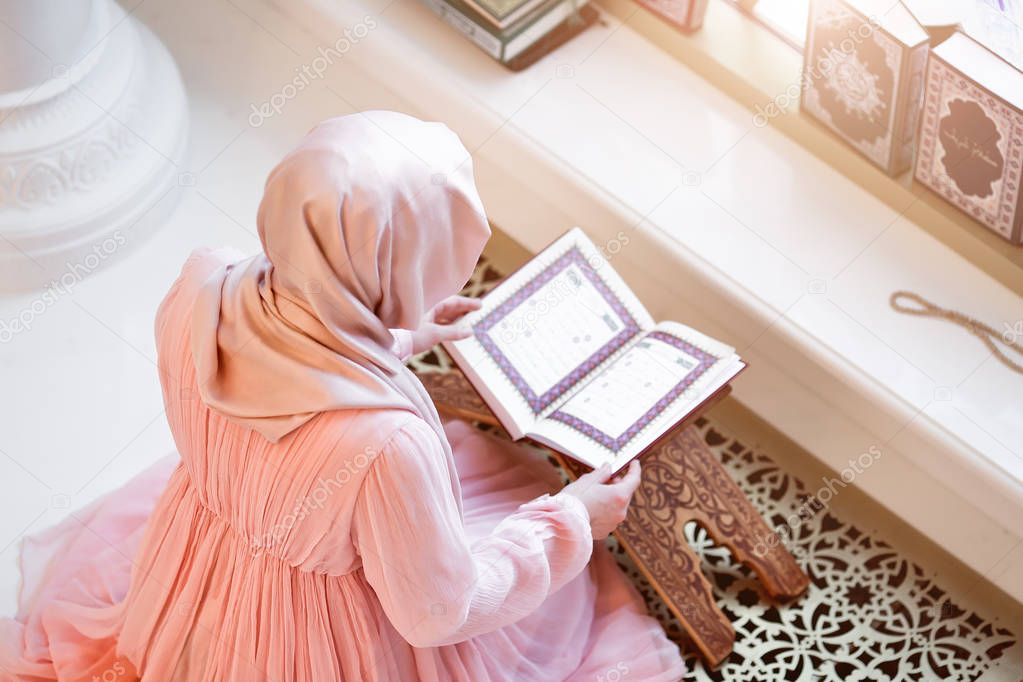 woman praying in the mosque and reading the Quran