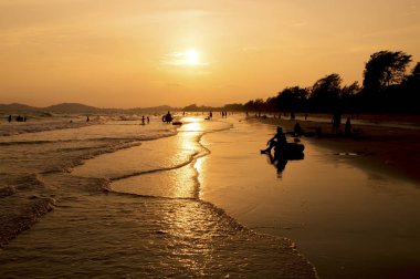 Gün batımında sahilde insan silueti.