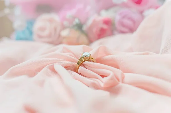 Close up of diamond ring on pink fabric for valentine day or wedding background