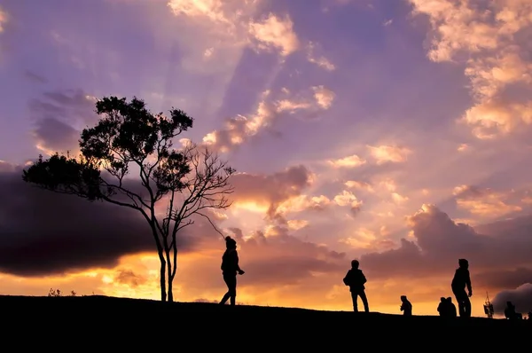 丘の上を歩く人々のシルエット — ストック写真