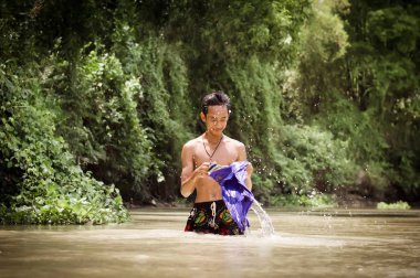 Nehirde su ile oynayan adam