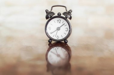 Masanın üzerinde çan ile siyah çalar saat