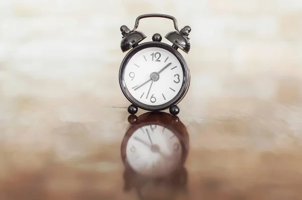 Masanın üzerinde çan ile siyah çalar saat