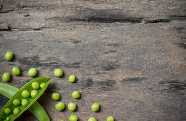 Eski ahşap arka planda yeşil bezelyeler