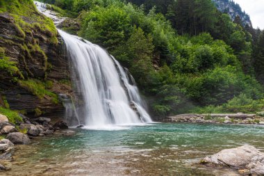 Güzel Piumogna şelalesinin Faido (CH) göletinde uzun süre görülmesi. Cennet gibi bir dağ manzarasının romantik bir kartpostalı.