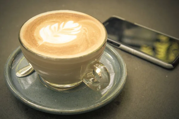 Vintage Toonbeeld Voor Een Kopje Art Coffee Met Mobiele Telefoon — Stockfoto