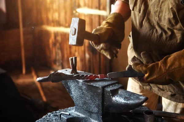 Blacksmith working on metal on anvil at forge high speed detail shot