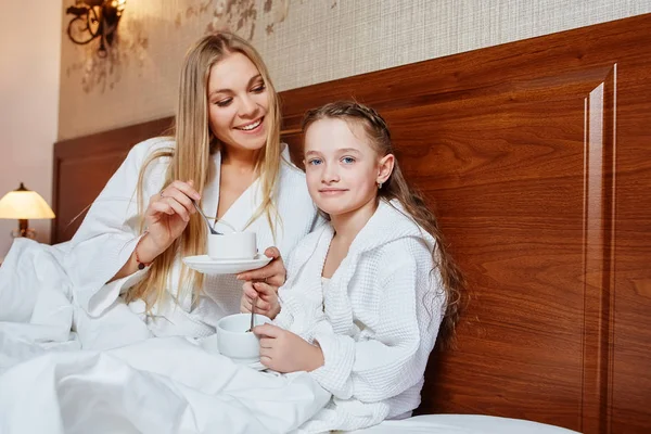 Sorridente madre e bambino hanno Colazione a letto, in un accogliente hotel — Foto Stock