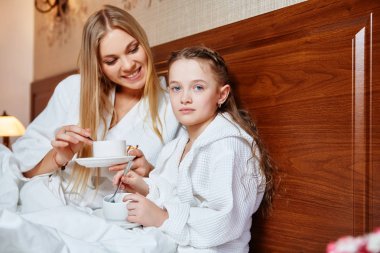 Gülümseyen anne ve çocuk yatakta Spa uygulamaları sonra dinlenme. Aile, sevgi, bakım kavramı