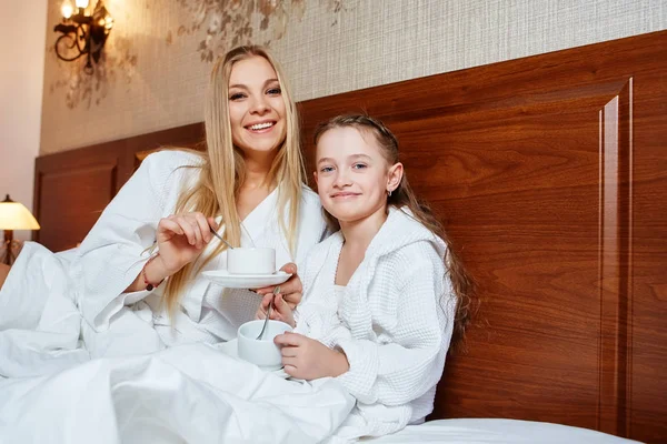 Gülümseyen anne ve çocuk yatakta Spa uygulamaları sonra dinlenme. Aile, sevgi, bakım kavramı