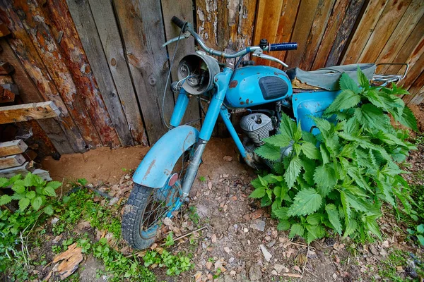 Een oude verlaten motorfiets-stand in de buurt van een hek in het dorp — Stockfoto