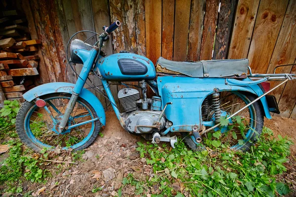 Staré opuštěné motocyklový stojan u plotu v obci — Stock fotografie