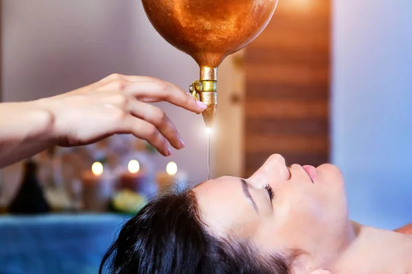 Женщина, наслаждающаяся массажем с аюрведическим маслом в спа — стоковое фото