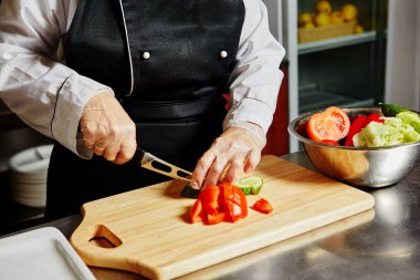 Şef kesim domates kesme tahtası üzerinde.