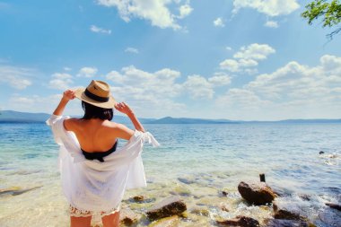 güzel ince kız rahatlatıcı bir büyük göl kayalık plaj