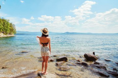 Bir ince kız beyaz bir gömlek ve bir hasır şapka onunla standları 