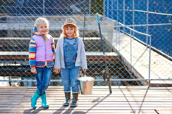 釣り竿と釣りのバケツ つの幸せな笑い子供旅行に 養魚場木製ポンツーン — ストック写真