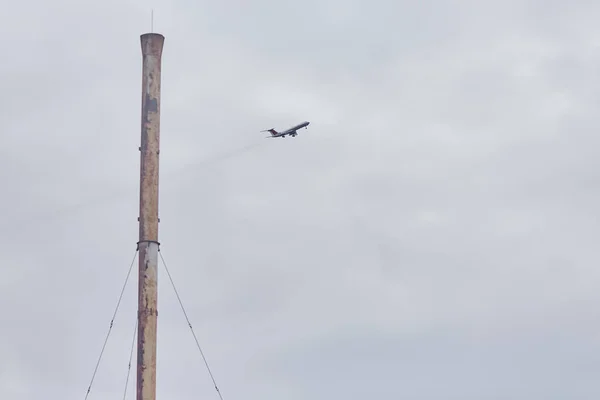 Самолет Пролетает Мимо Высокой Трубы — стоковое фото