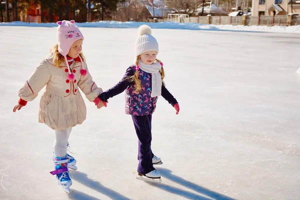 Två Små Flickor Hålla Händer Och Skate — Stockfoto