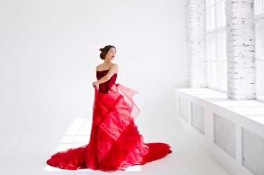 Kırmızı elbiseli bir genç bir kadın dans ediyor. Latin tarzı. Beyaz izole