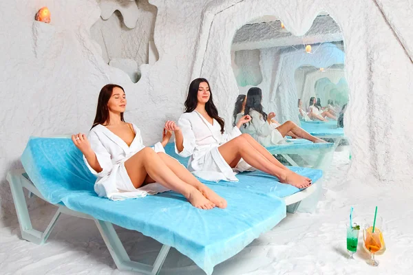 İki genç kadın tuz odasında meditasyon.
