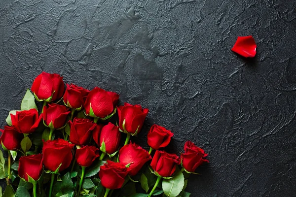 Red roses on a black textured background. Place for text, top vi — Stock Photo, Image